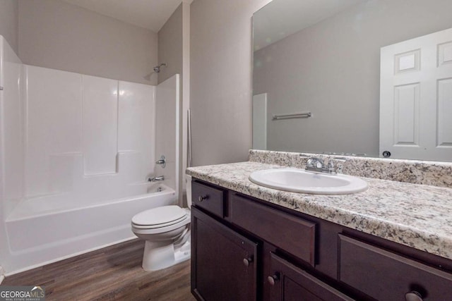 full bathroom with vanity, toilet, hardwood / wood-style flooring, and  shower combination