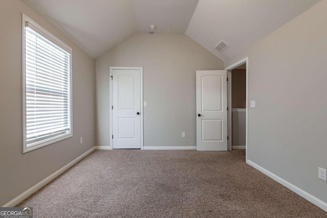 unfurnished bedroom featuring vaulted ceiling and carpet flooring