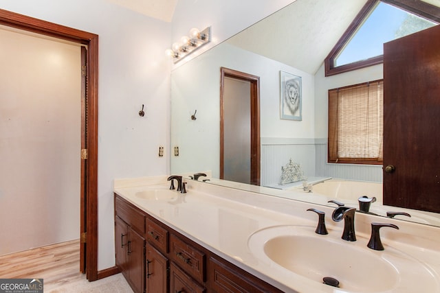 bathroom with a bathtub, vanity, wood-type flooring, and vaulted ceiling