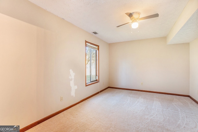 empty room with carpet, ceiling fan, and a textured ceiling