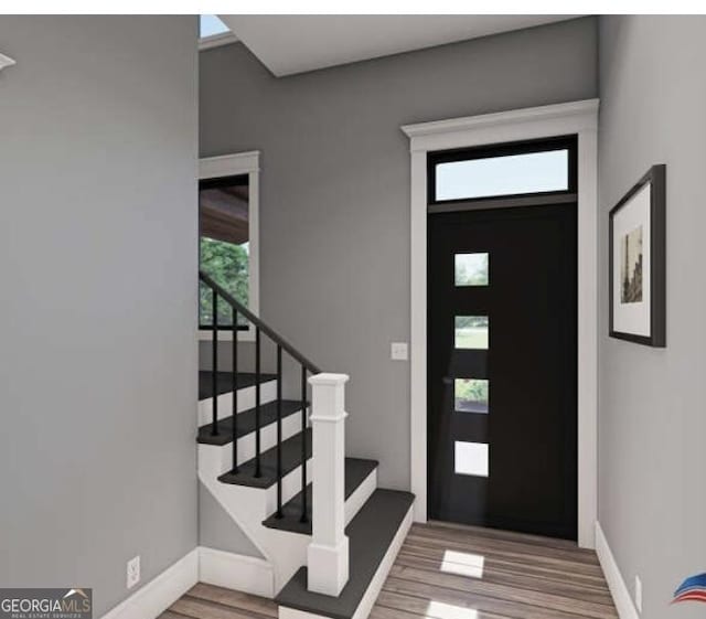 entrance foyer featuring baseboards, wood finished floors, and stairs