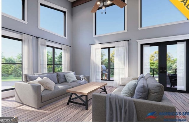 living room with a towering ceiling, a wealth of natural light, and french doors