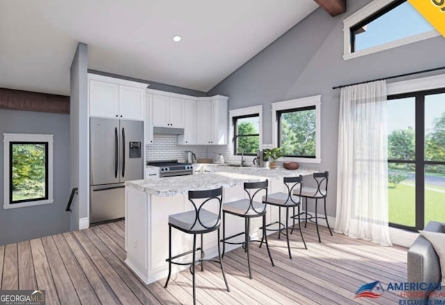 kitchen featuring plenty of natural light, white cabinets, light hardwood / wood-style floors, and appliances with stainless steel finishes