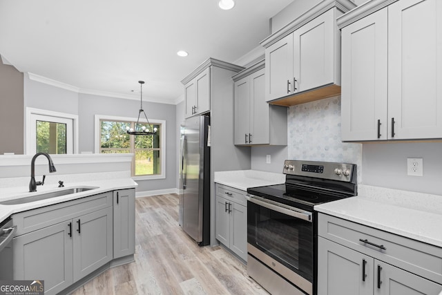 kitchen with light hardwood / wood-style floors, sink, crown molding, appliances with stainless steel finishes, and gray cabinetry