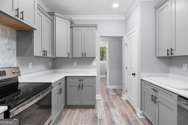 kitchen featuring stainless steel appliances, ornamental molding, and gray cabinets