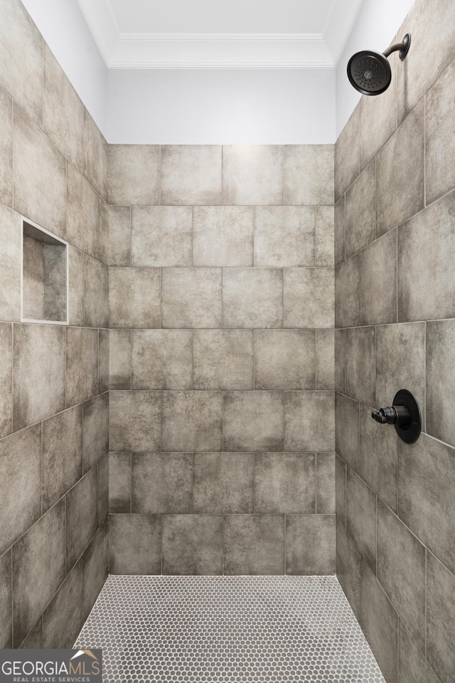 interior details featuring crown molding and a tile shower