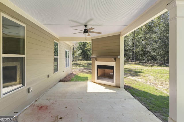 view of patio featuring ceiling fan and an outdoor fireplace