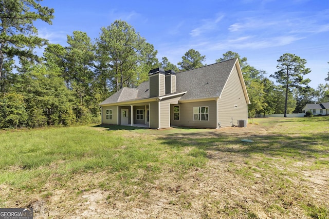 back of house featuring cooling unit and a yard