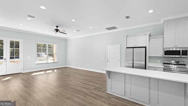 kitchen with white cabinetry, stainless steel appliances, french doors, ceiling fan, and crown molding