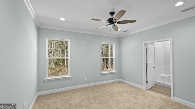 unfurnished bedroom with a walk in closet, light carpet, a closet, ceiling fan, and crown molding