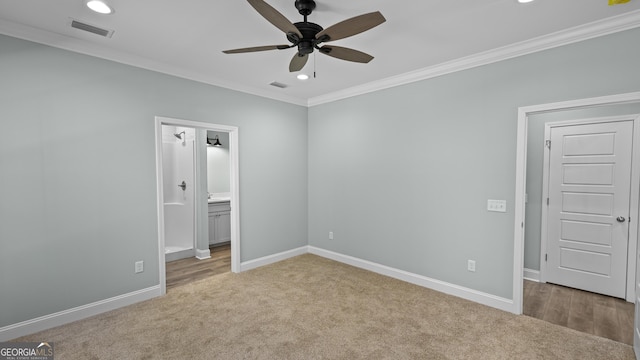 unfurnished bedroom featuring ceiling fan, ensuite bath, ornamental molding, and light carpet