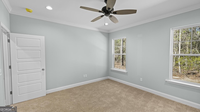 unfurnished room featuring light colored carpet, a wealth of natural light, and crown molding