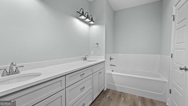 bathroom with vanity, a washtub, and hardwood / wood-style floors