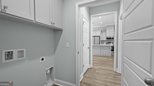 laundry room featuring electric dryer hookup, light wood-type flooring, hookup for a washing machine, cabinets, and crown molding