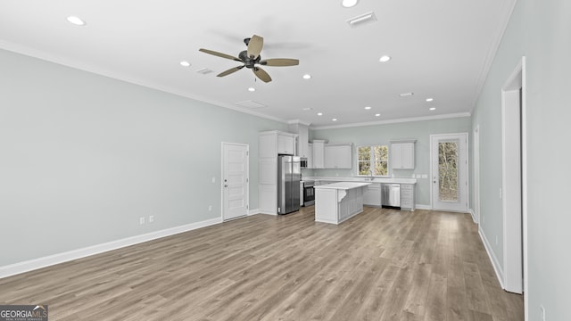 kitchen featuring ceiling fan, a kitchen island, white cabinetry, ornamental molding, and stainless steel appliances