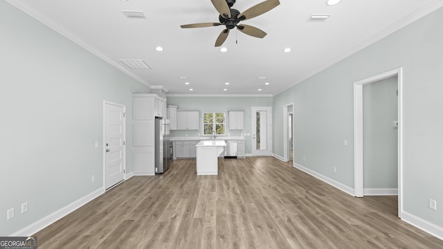 unfurnished living room featuring ceiling fan, light hardwood / wood-style floors, sink, and ornamental molding