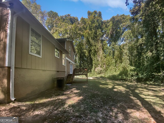 view of yard with a deck and central air condition unit