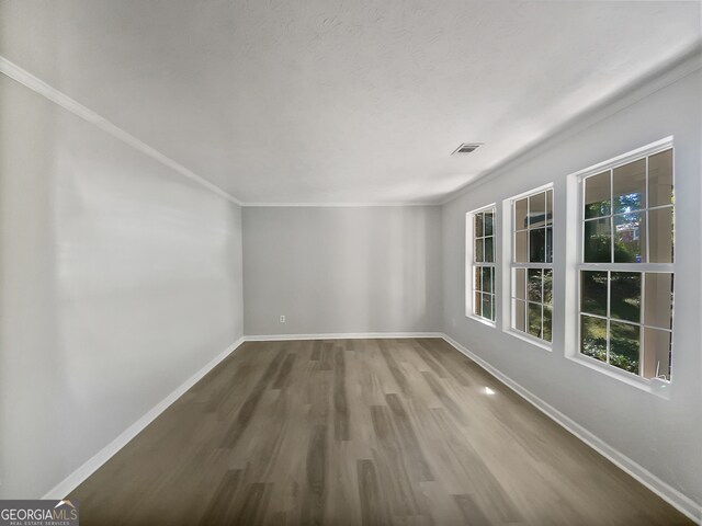 spare room with crown molding and hardwood / wood-style floors