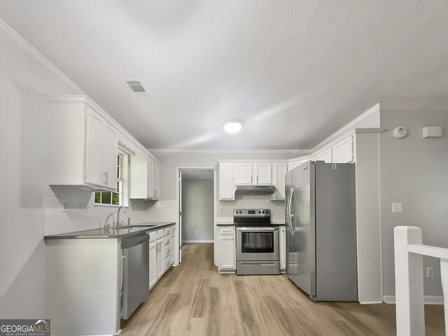 kitchen featuring sink, crown molding, white cabinetry, appliances with stainless steel finishes, and light hardwood / wood-style floors