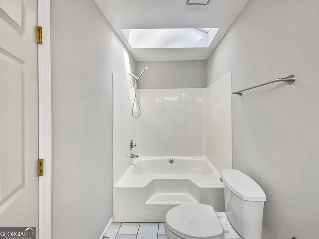 bathroom featuring toilet, a skylight, and tub / shower combination