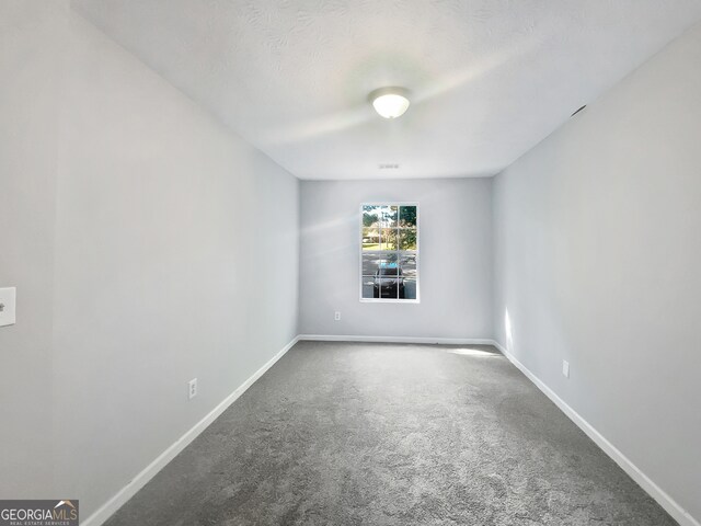 carpeted spare room featuring a textured ceiling