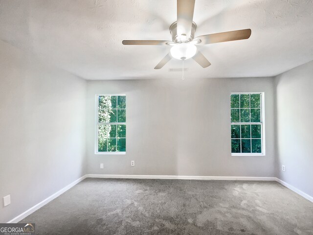 empty room with a textured ceiling, carpet floors, and ceiling fan