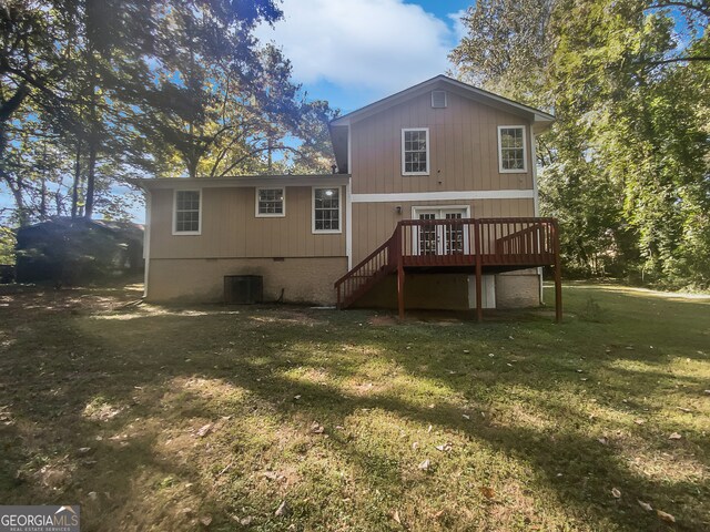 back of property with a wooden deck and a yard