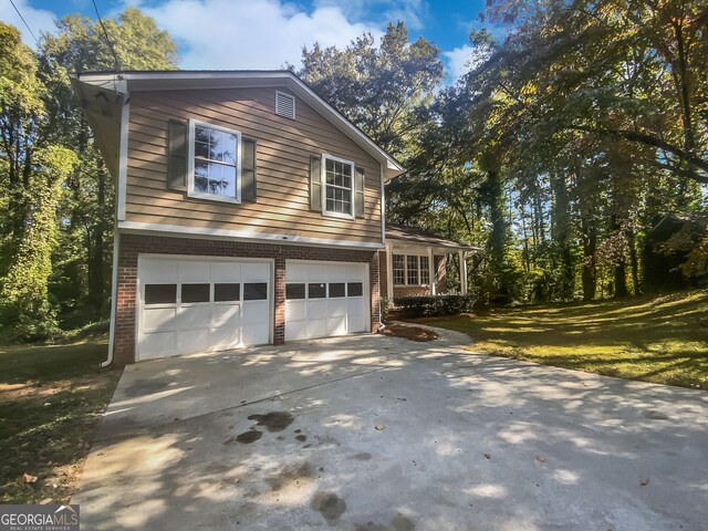 view of side of home featuring a garage and a lawn