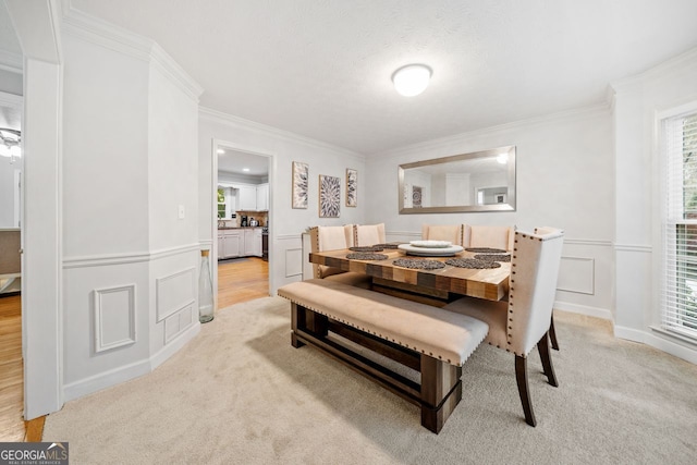 carpeted dining space with a healthy amount of sunlight and crown molding