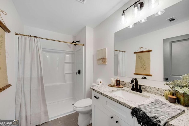 bathroom featuring toilet, walk in shower, vanity, and tile patterned flooring