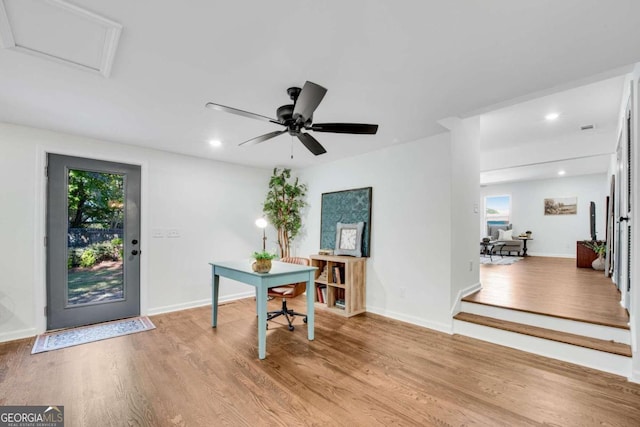 office with light wood-type flooring and ceiling fan