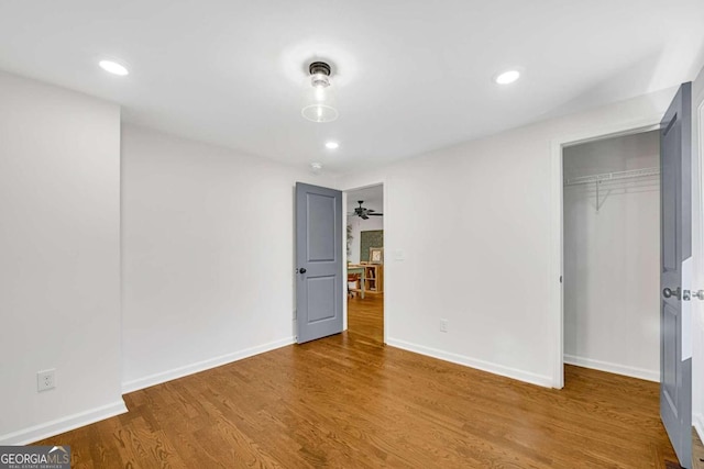 unfurnished bedroom featuring wood-type flooring and a closet