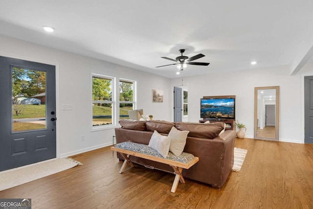 living room featuring light wood-type flooring and ceiling fan