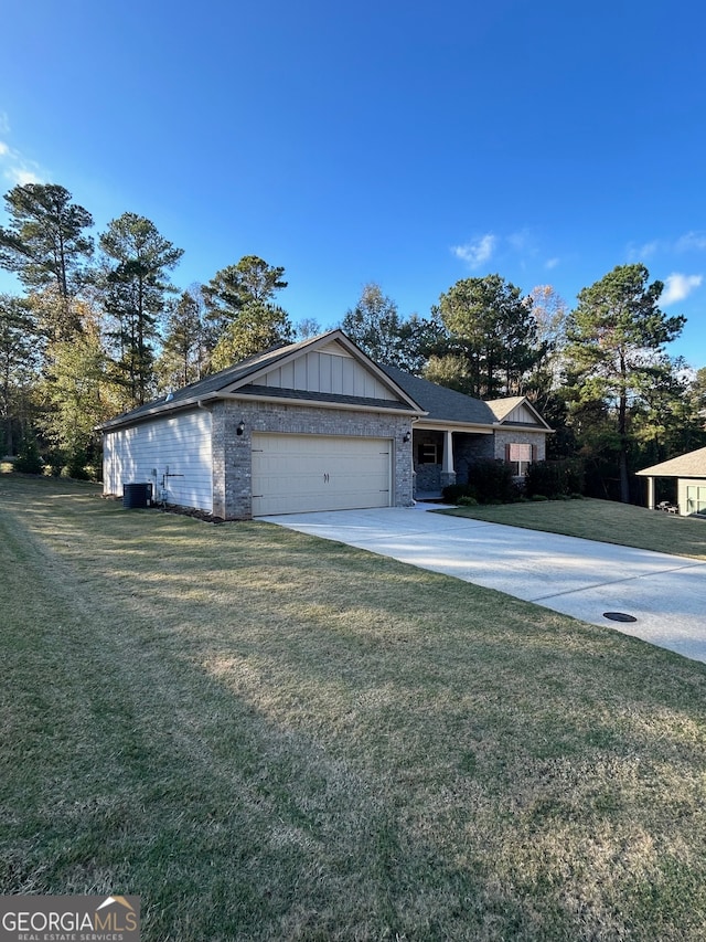 view of front of property featuring a garage, central AC, and a front lawn