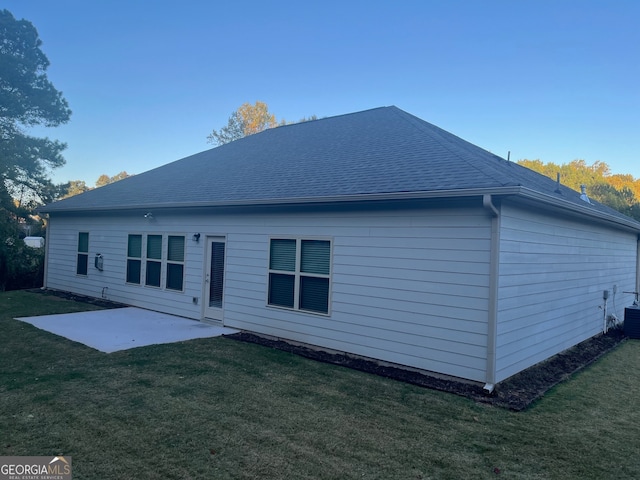 rear view of house with a patio and a lawn