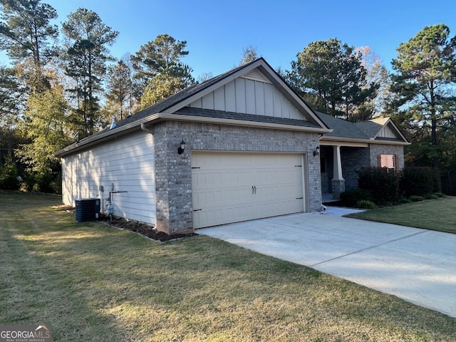 view of front of home featuring a garage, cooling unit, and a front yard