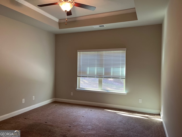 carpeted spare room with ceiling fan, crown molding, and a raised ceiling