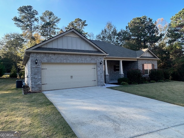 view of front of house featuring a garage, cooling unit, and a front yard