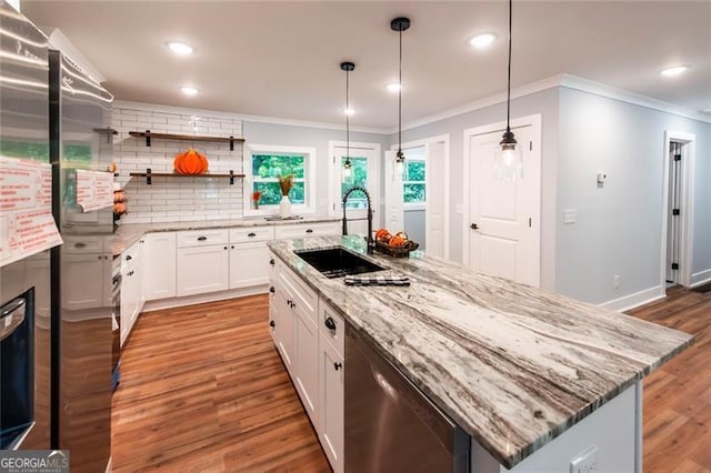 kitchen with hardwood / wood-style flooring, a center island with sink, sink, white cabinetry, and appliances with stainless steel finishes