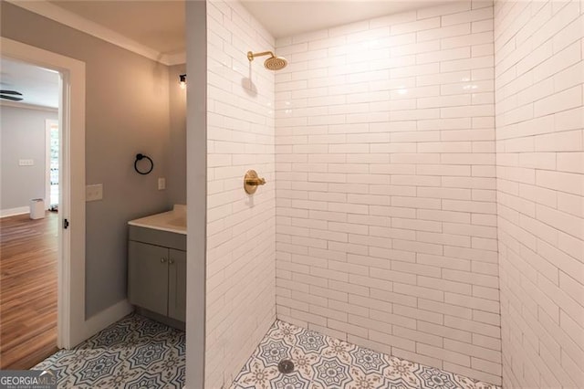 bathroom with vanity, a tile shower, and wood-type flooring