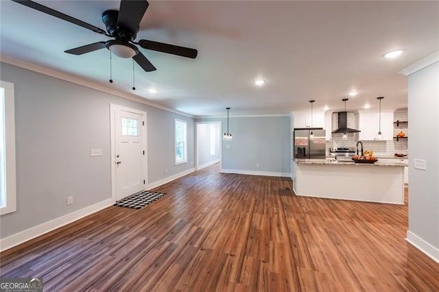 unfurnished living room featuring crown molding, wood-type flooring, and ceiling fan