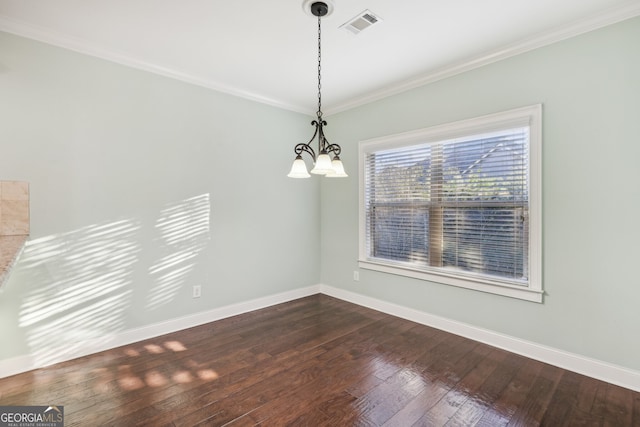 empty room featuring ornamental molding, dark hardwood / wood-style floors, and an inviting chandelier