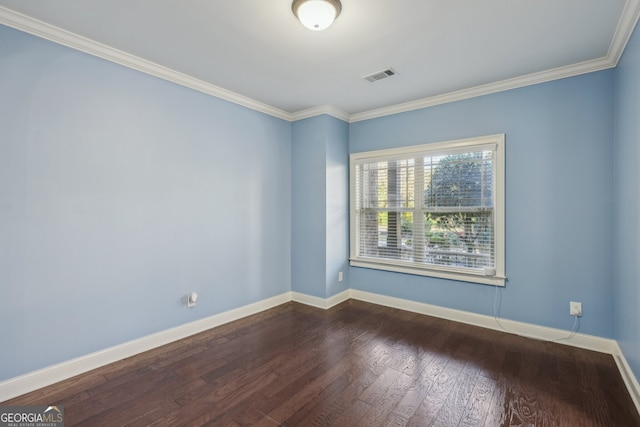 empty room with hardwood / wood-style floors and crown molding