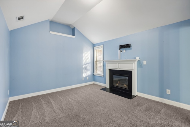 unfurnished living room featuring carpet and vaulted ceiling