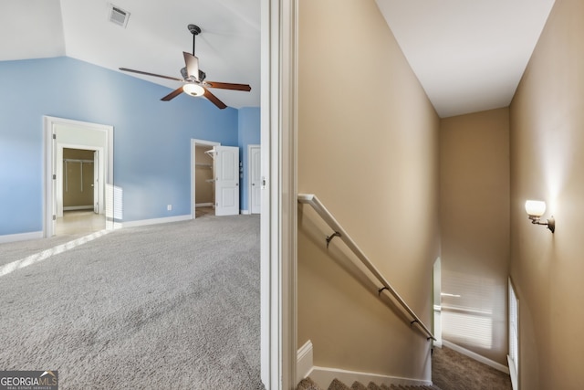 staircase with carpet floors, ceiling fan, and vaulted ceiling