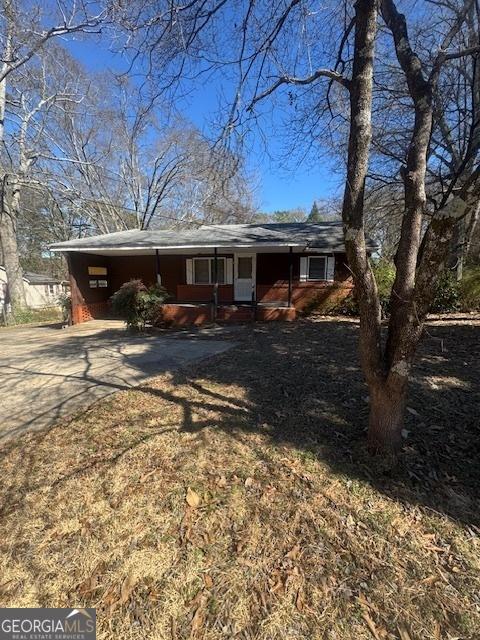 exterior space featuring concrete driveway and a porch