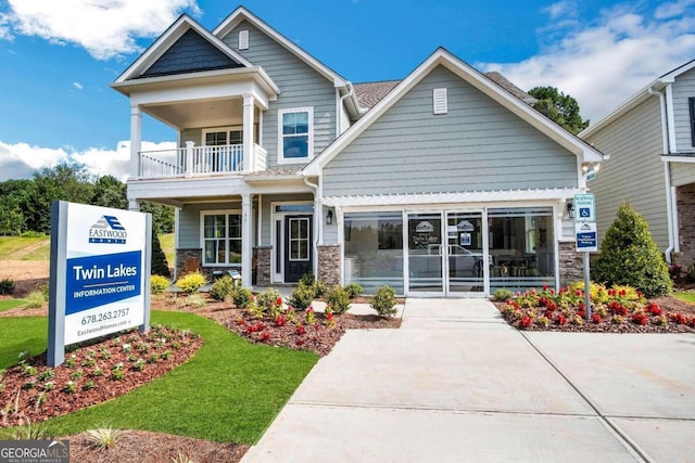 craftsman inspired home with a front yard and a balcony