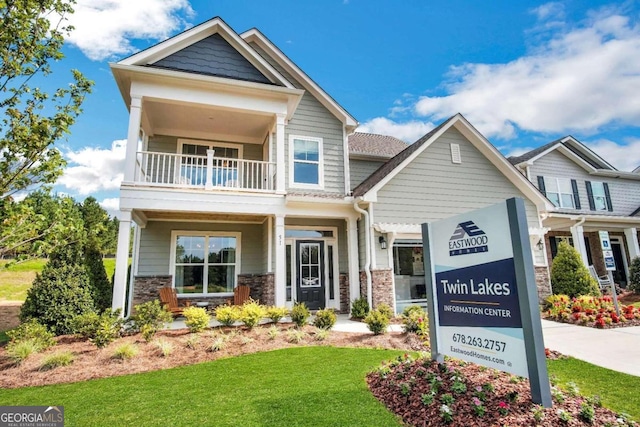 craftsman-style home featuring a front yard and a balcony