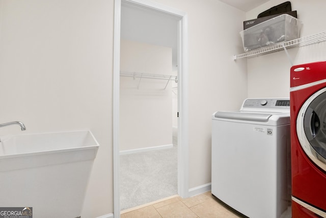 laundry room with sink, washing machine and dryer, and light tile patterned floors