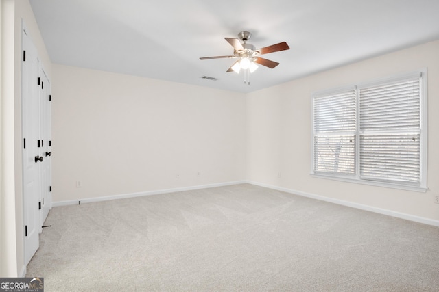 empty room featuring light colored carpet and ceiling fan